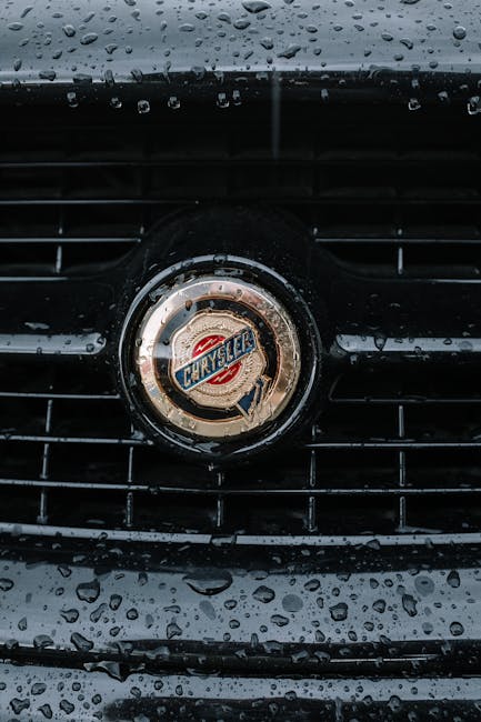 Raindrops on a classic Chrysler car grille detail captured in a close-up shot.